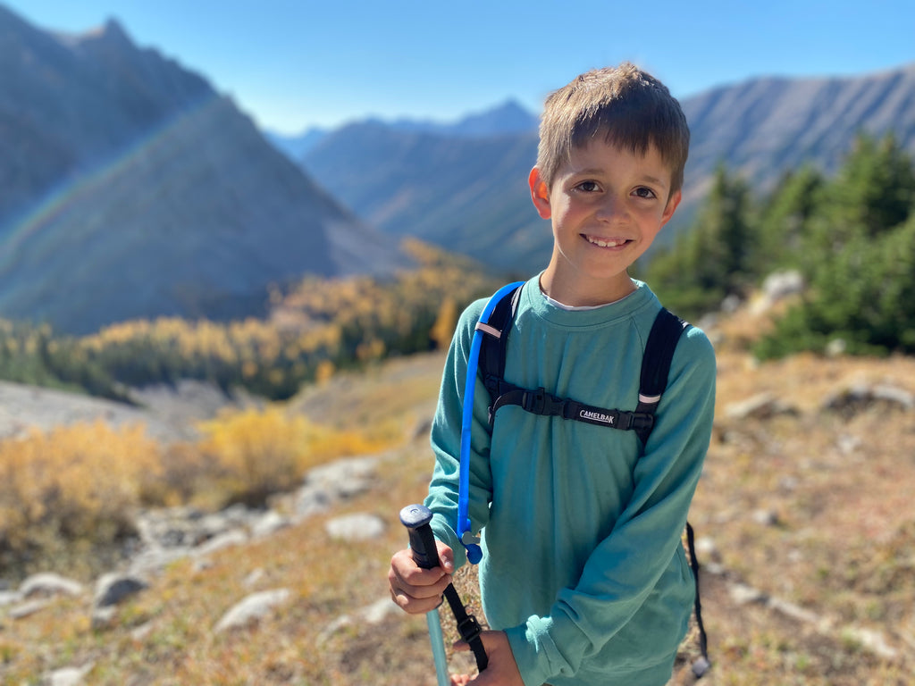 photo of young boy hiking among the mountains 