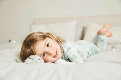 child in green tie dye PJs