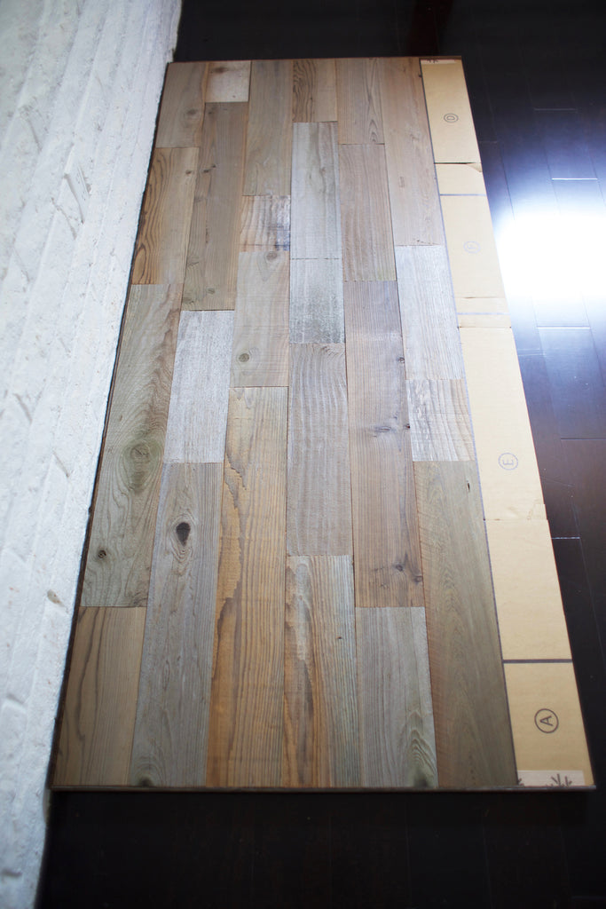 A reclaimed wood headboard diy project is laid out on the floor.