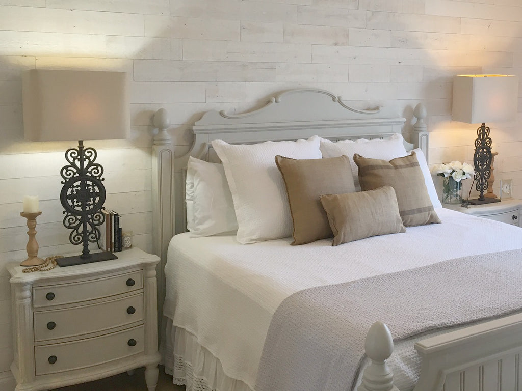 Reclaimed wood paneling adds dimension and depth to a master bedroom in a way that’s reminiscent of art deco style.