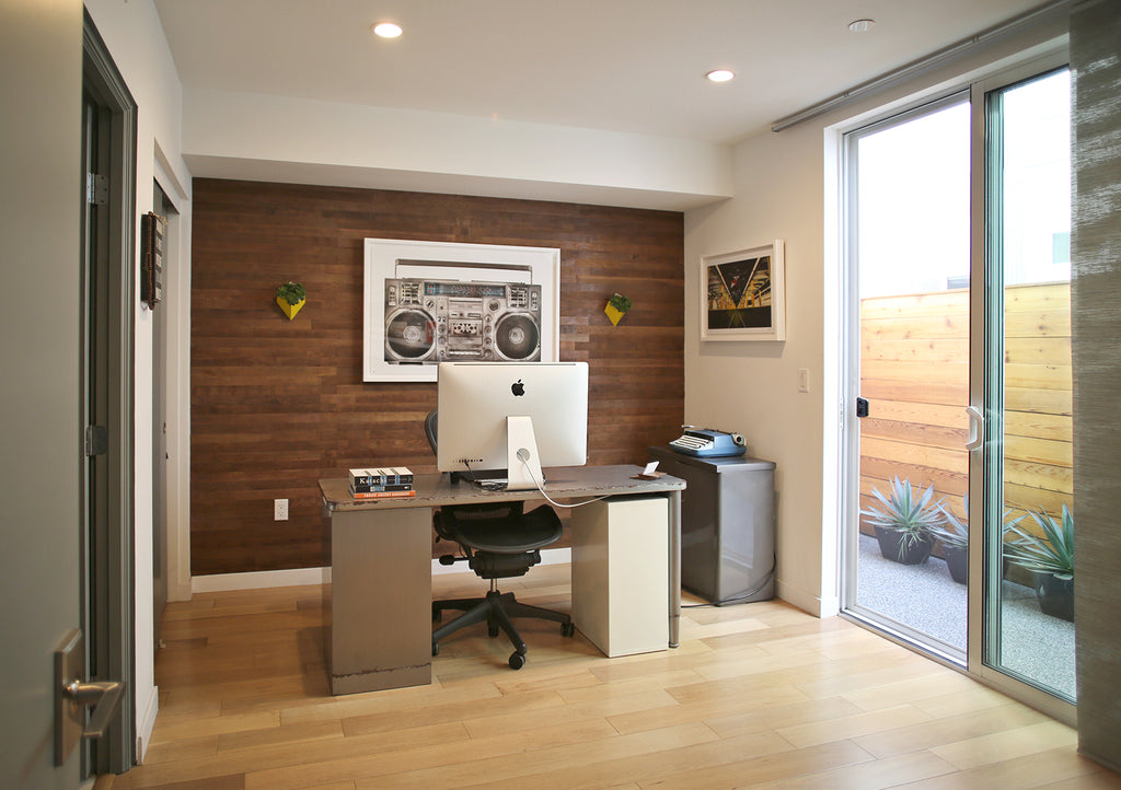 A home office with a reclaimed wine barrel wood wall. 