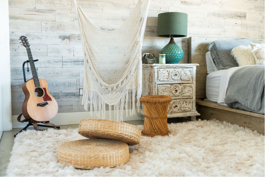 wood walls in a boho style bedroom with a crocheted swing