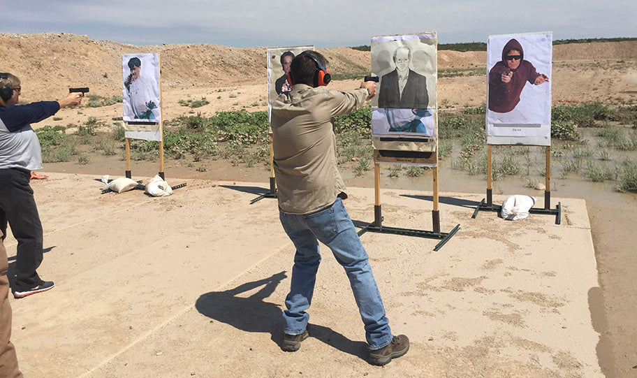 Two civilians practice shooting in front of targets