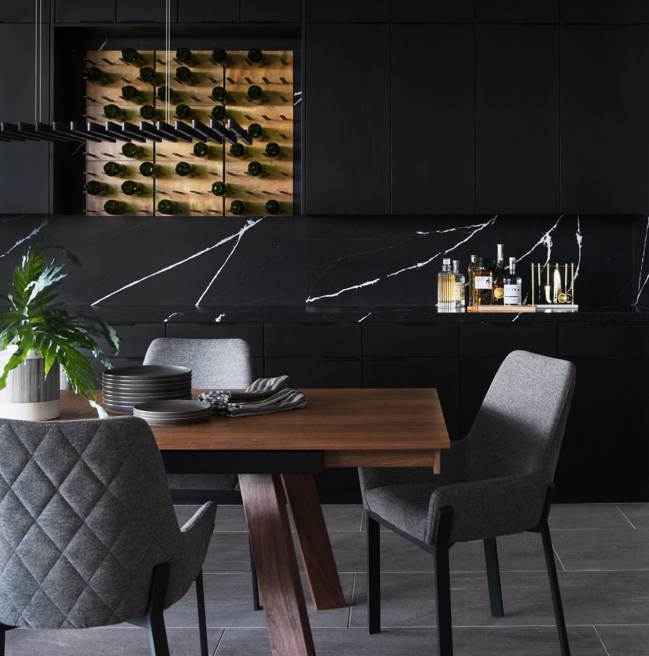 wine nook with wood panel and metal peg racks on black marble