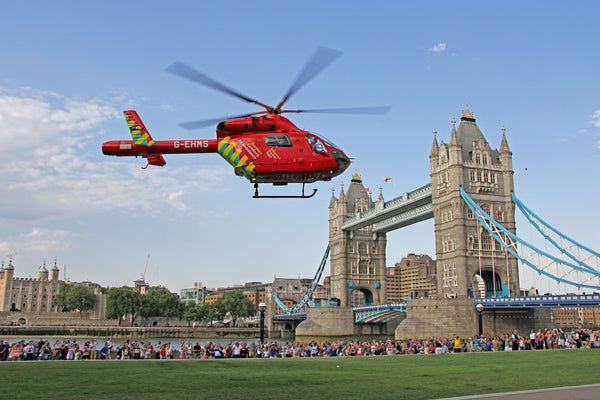 A Lonodn air ambulance helicopter flying over tower bridge