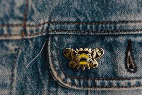 A bumblebee enamel pin designed in the Acoma Pueblo style