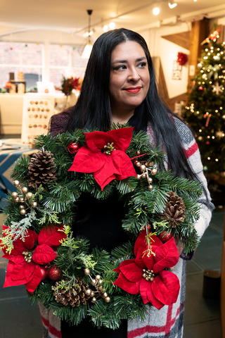 Colleen holds a wreath at the flagship store at Pike Place Market