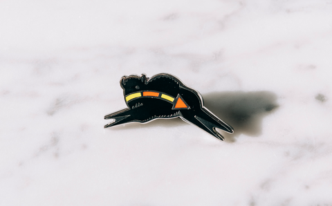 An enamel pin with a black buffalo designed by a Blackfeet artist