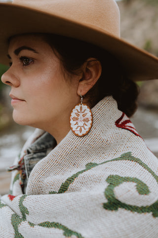 Birch Bloom earrings worn by a woman wearing a hat
