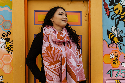 Maple Sugar Gold Label Wool Scarf by Sarah Agaton Howes (Anishinaabe/Ojibwe) is a pink, orange, and white wool scarf with maple leaf designs.