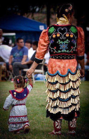 A woman and her toddler daughter in their jingle dress regalia.