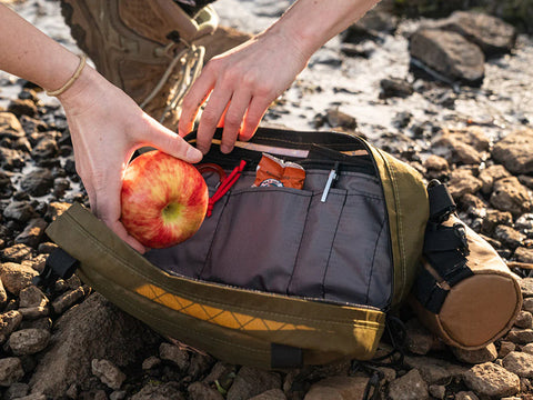 Pioneer 12 Handlebar Bag being loaded with snacks on a trail.