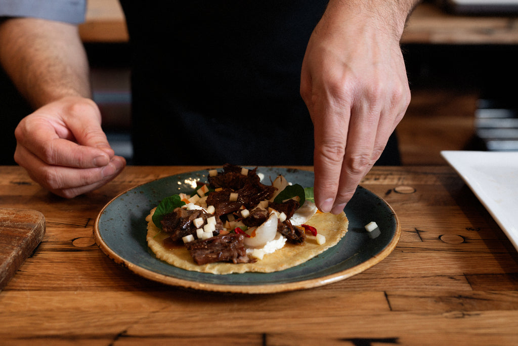 Braised bison pannekoek being prepared on wood counter top