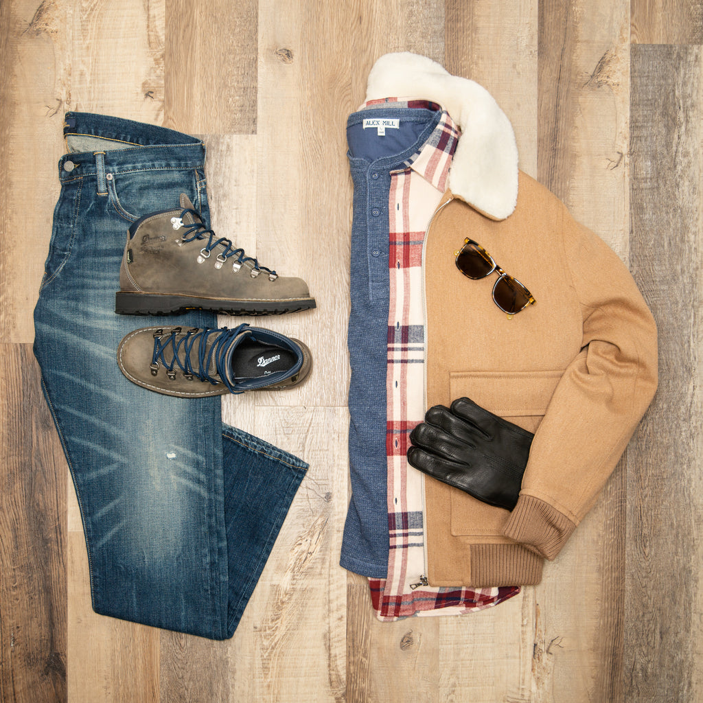 Flat lay image of ralph lauren polo jeans, bronze APC bomber, cream and red portuguese flannel shirt, and blue henley shirt