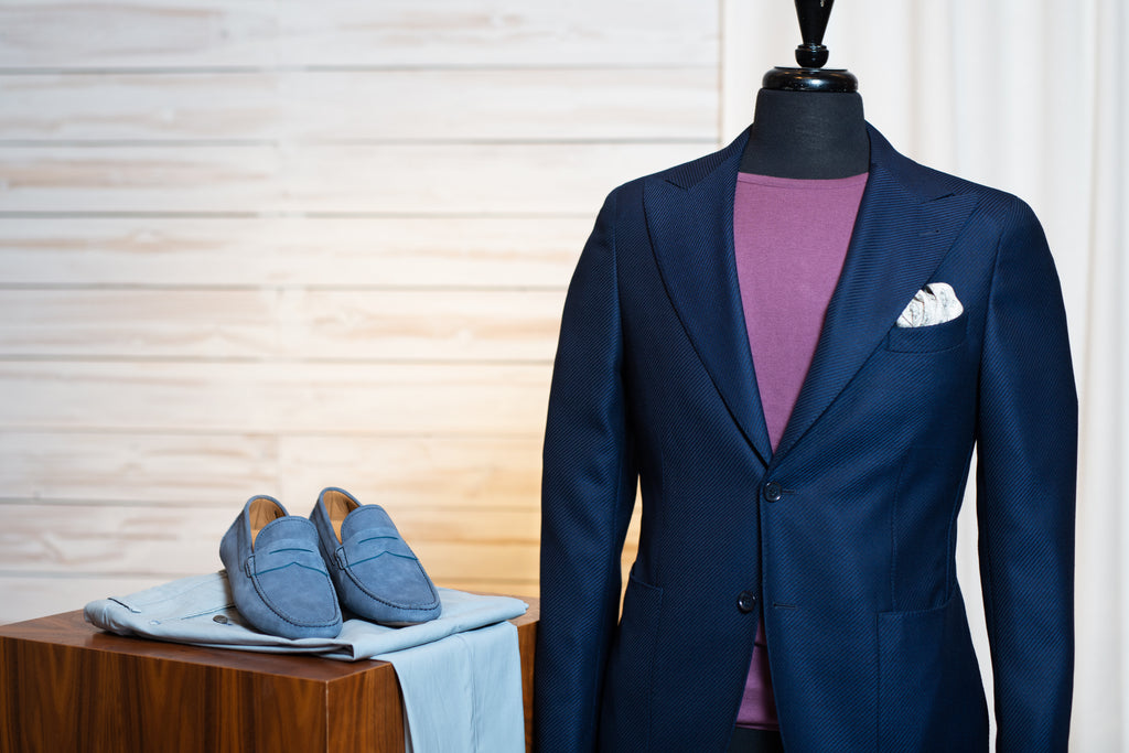 Corneliani CC navy sport jacket worn with light grey trousers, purple knit t-shirt, and blue suede driving shoes