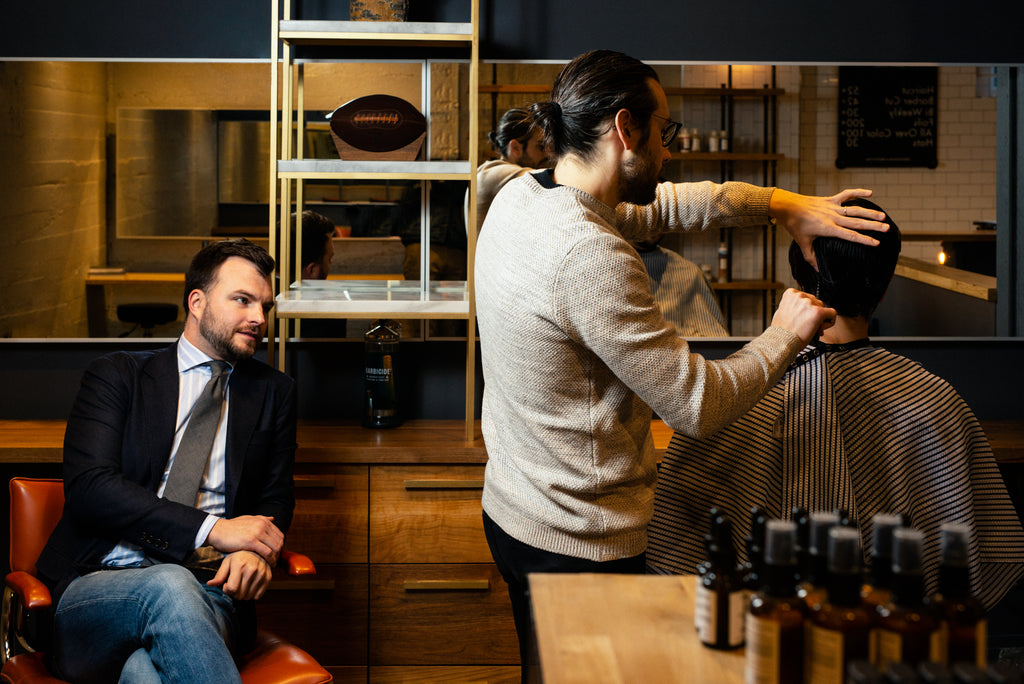 Craig Boa and Chad Helm chatting while Craig cuts hair at Weekly