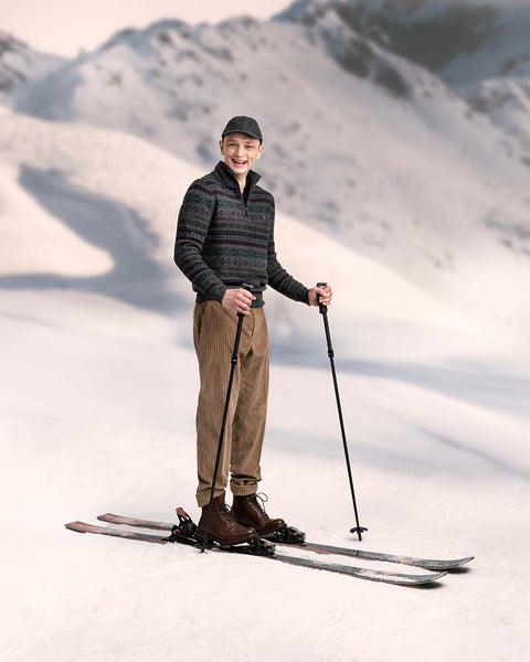 skiier in hat, trousers, and sweater