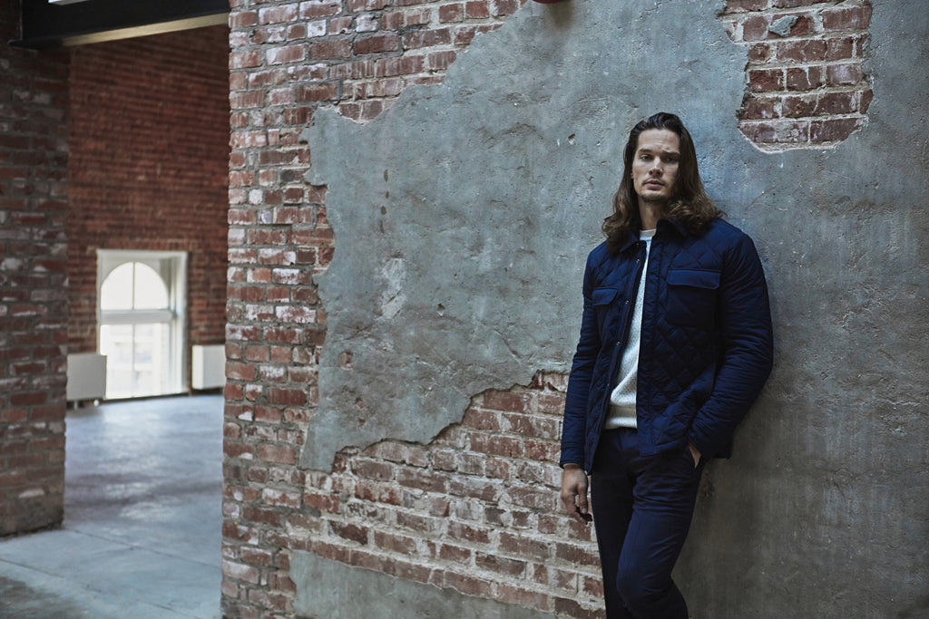 Ermenegildo Zegna - The Helm 2019 campaign - Joey in navy quilted jacket standing by brick wall