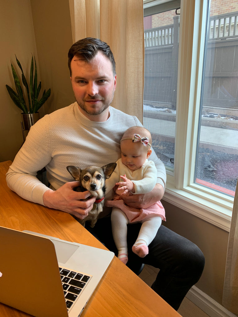 Chad Helm with baby and dog working at home