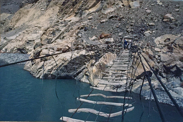 An eye-level view of a rickety bridge high up over a river in Northern Pakistan.