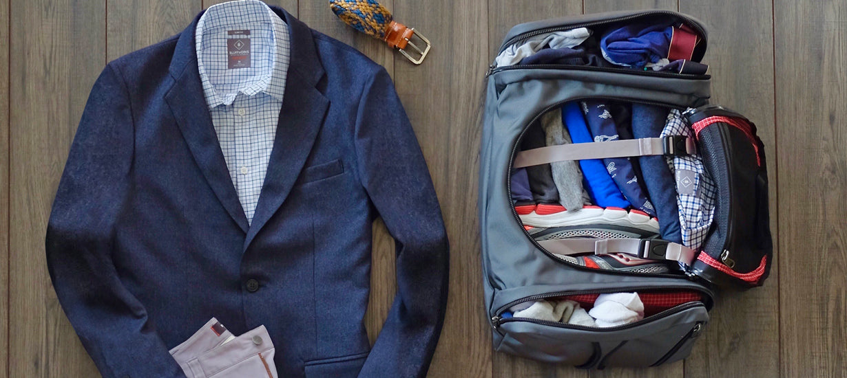 A duffle bag packed full with a suit laid out next to it.