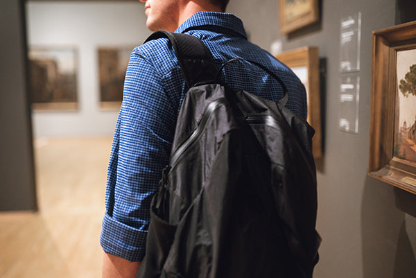 Tourist in museum wearing a backpack.