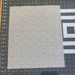 Piece of fabric siting on a quilting cutting mat