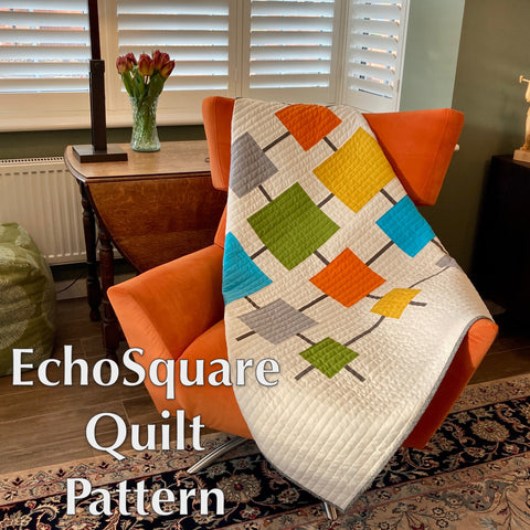 EchosSquare mid-century modern quilt sitting on an orange chair pattern