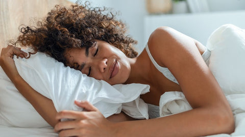 Sleeping with her curly hair, illustrating the importance of quality rest for promoting healthy hair growth and preventing hair loss.