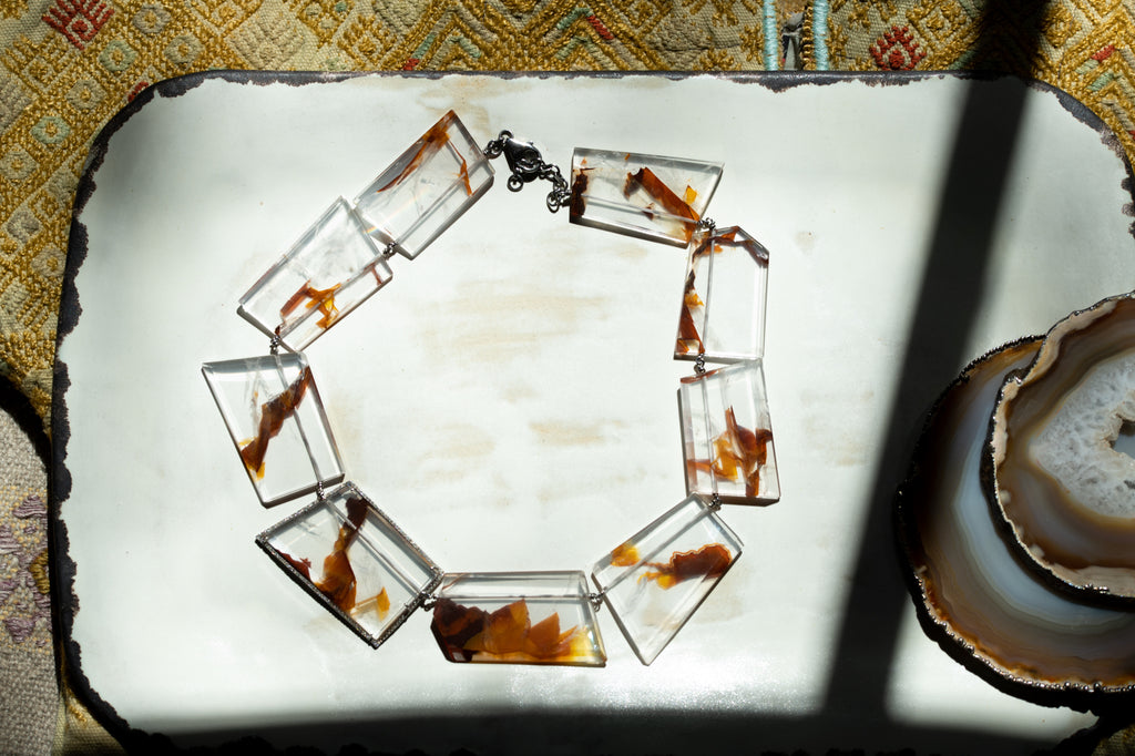 Sliced gem necklace on a ceramic plate in the sunlight. 