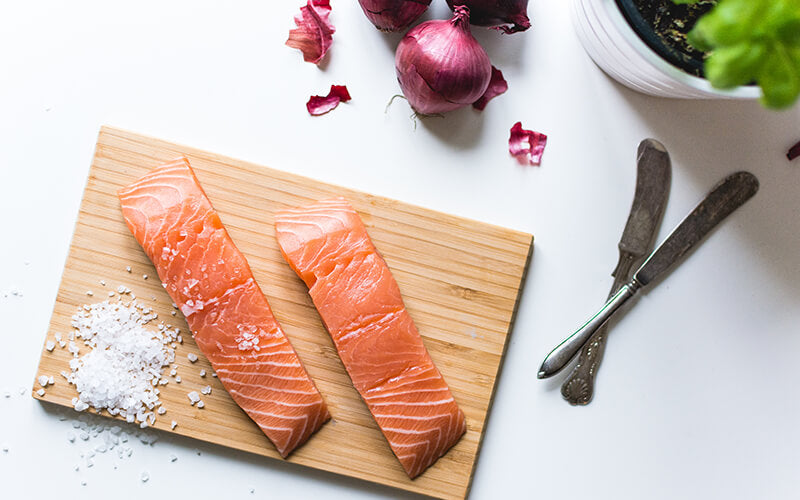 Salmon with salt on wooden board