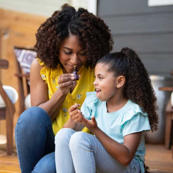 Mom and daughter smelling essential oil on the porch