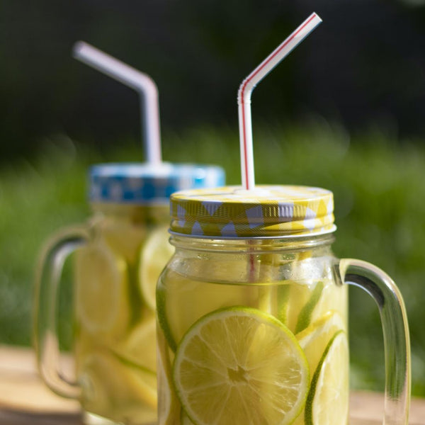 Mason jar with lemon water and straw.