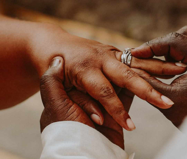 Hands of a man and woman exchanging wedding rings.