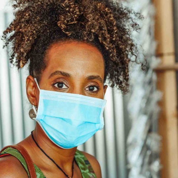 Black woman wearing a surgical face mask.