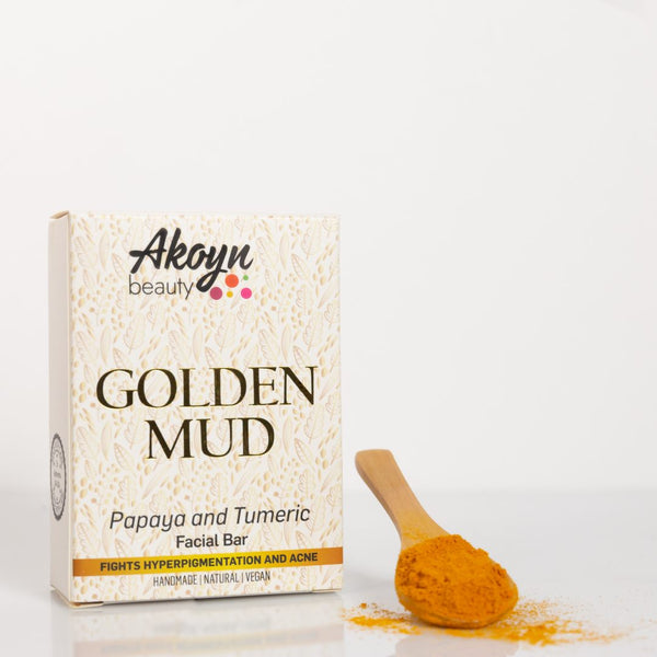 Akoyn Beauty Golden Mud soap bar beside a turmeric powder on a spoon.