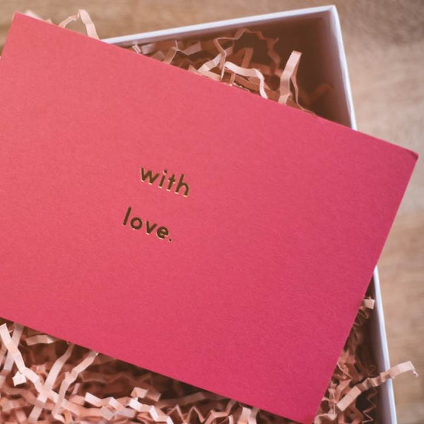 With love pink card on a gift box.