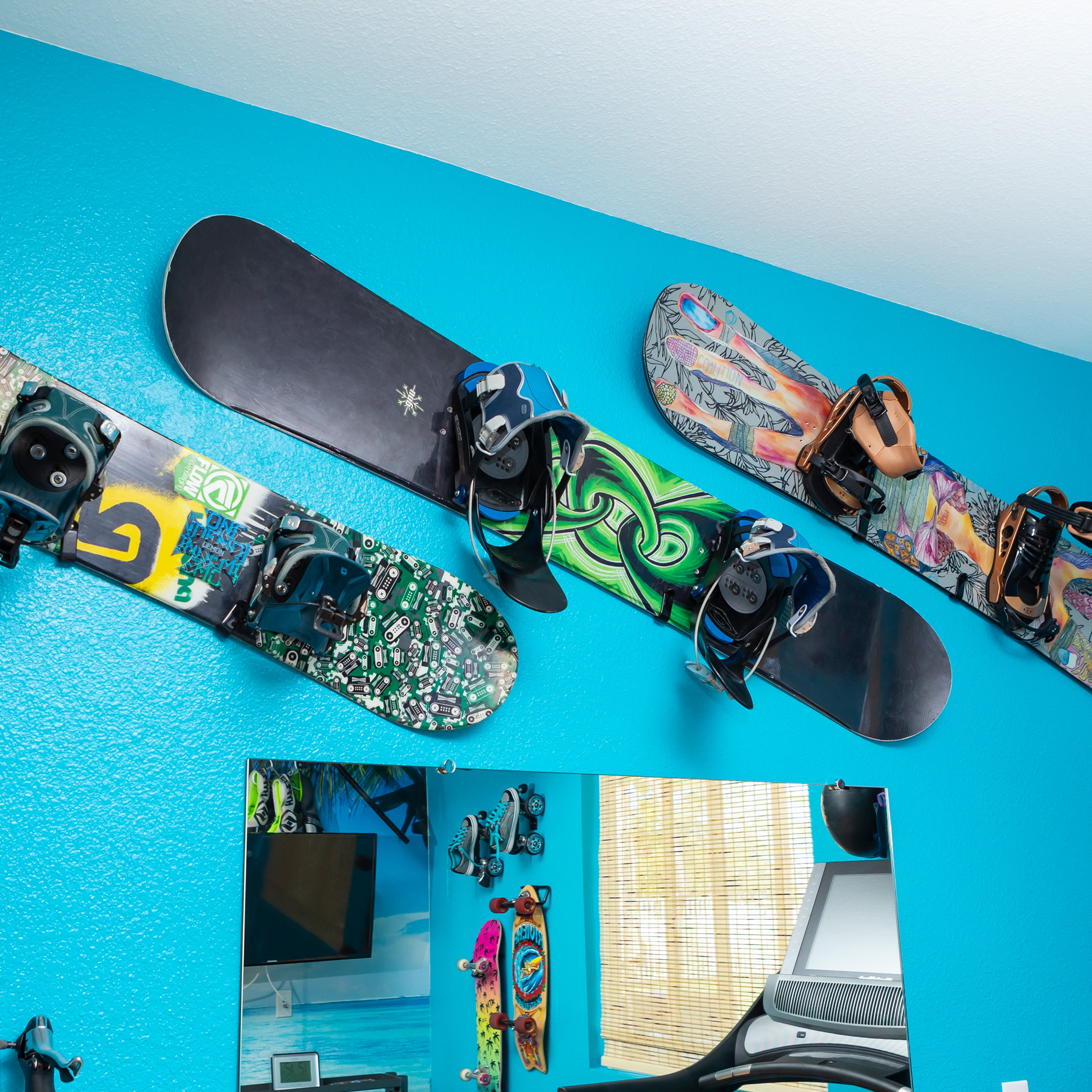 Three snowboards displayed in HIDEit Horizontal Snowboard Mount Clips.