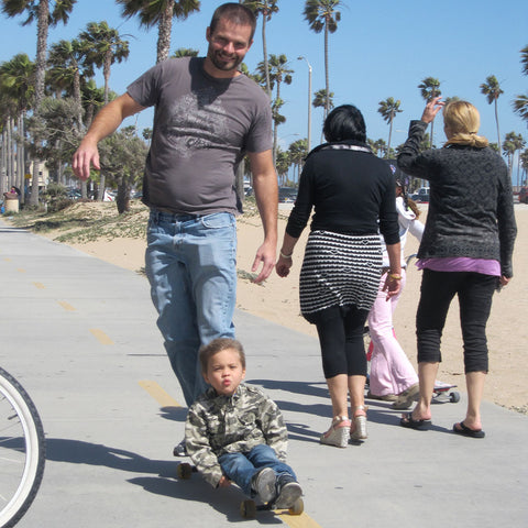 Dad riding a longboard with a child in Newport Beach