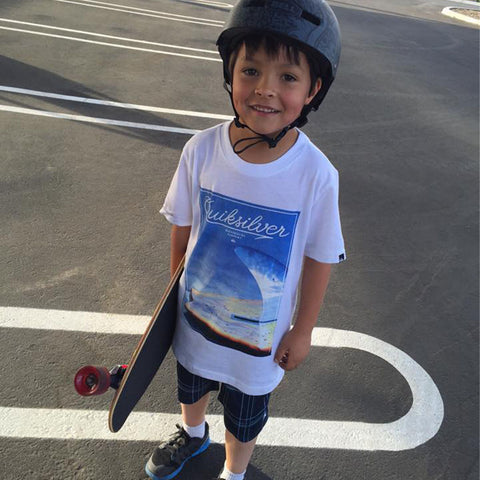 Young boy with complete skateboard and helmet