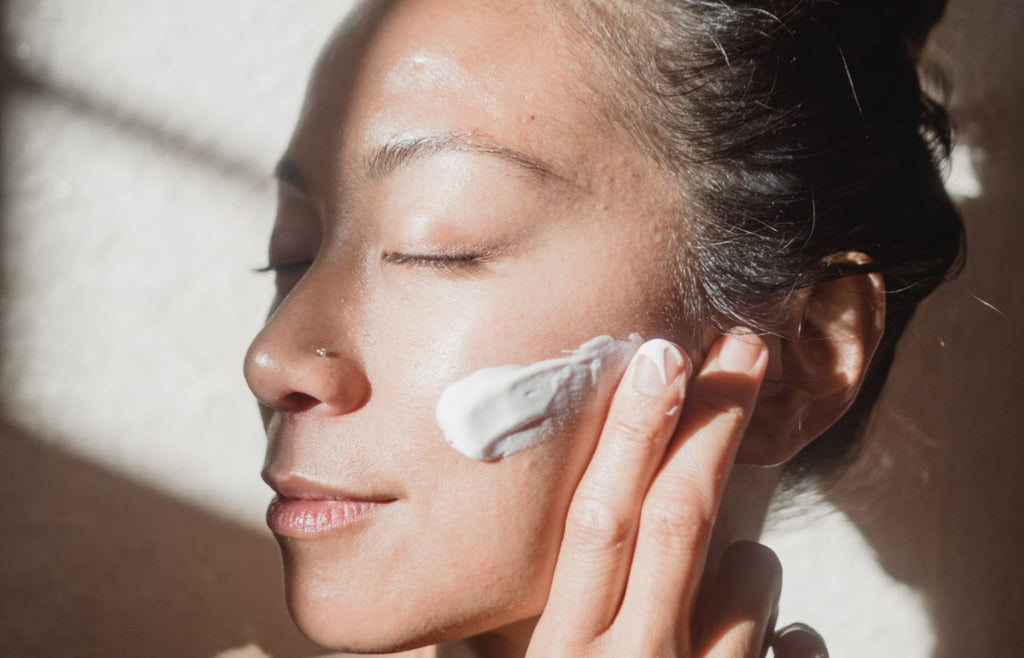 woman applying moisturizer with spf