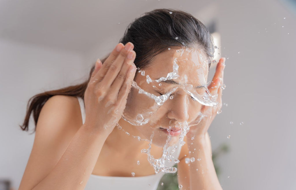 Woman rinsing face in sink