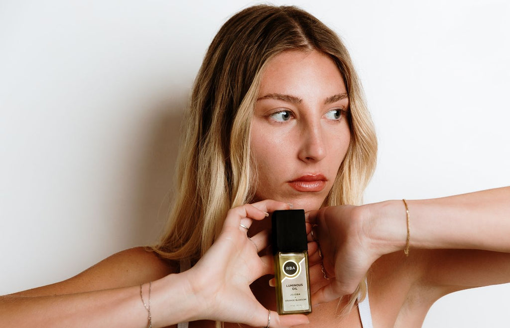 fresh faced woman holding hydrating facial oil