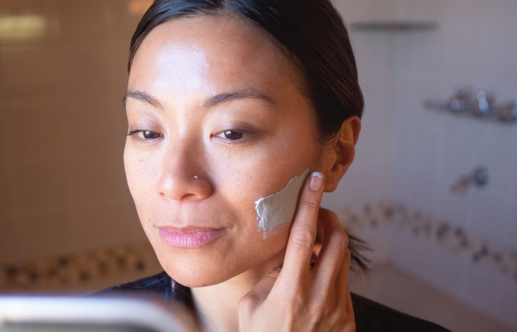 woman applying detoxifying clay mask