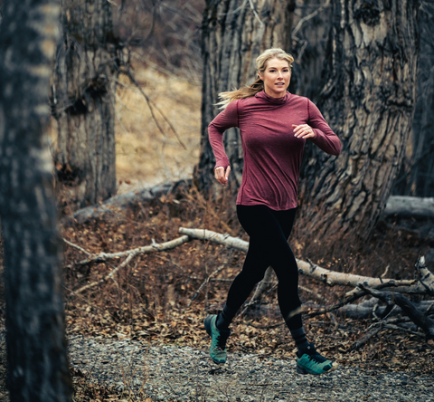 woman running through s wooded area