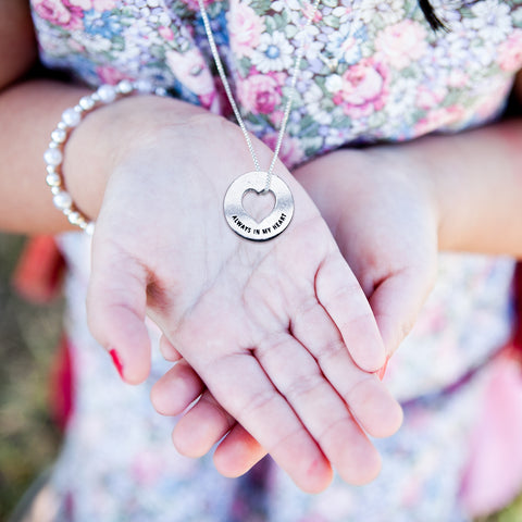 woman holding blessing ring on necklace in hand