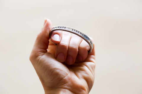 person holding quotable cuff bracelet