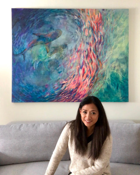 Artist Grace Marquez at her home studio in front of her painting "Circling"