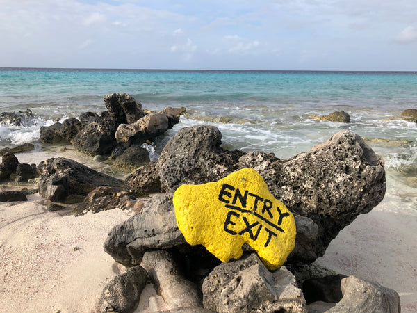Painted rocks marking the entry and exit points of a shore dive in Bonaire