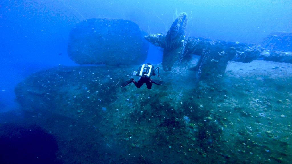 Diver descending onto the props of the upside down Nagato wreck in Bikini Atoll